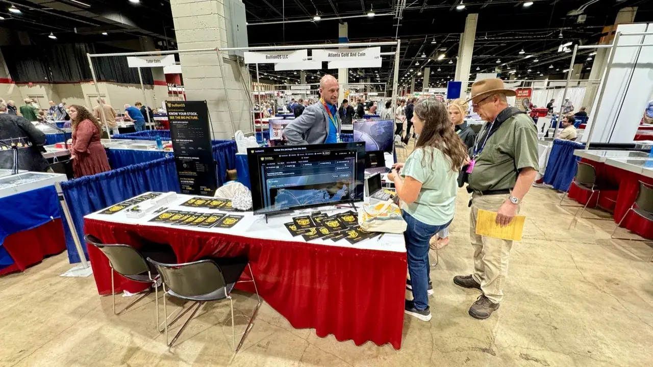 Attendees watching a bullionOS precious-metals dealer software demo at the bullionOS booth at GACC 2026 in Rosemont, IL