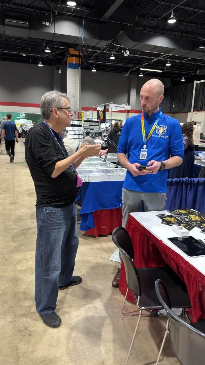 bullionOS representative talking with an attendee about bullionOS software at the 2026 GACC coin show near Chicago